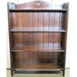 A small oak freestanding open bookcase with four fixed shelves, reeded detail, pierced shaped and