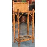 A late Victorian bamboo two divisional umbrella/stickstand with rectangular panelled back and