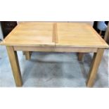 A contemporary light oak pull-out extending dining table of rectangular form with single