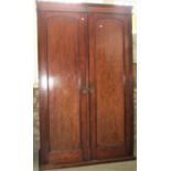 A late Victorian mahogany wardrobe enclosed by a pair of full length rectangular and arched