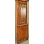 A reproduction Georgian style figured and burr walnut veneered bow fronted freestanding corner