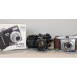 An Olympus OM-1 camera, a Nikon digital camera Coolpix 7900 and a Retinette Compur-Rapid camera (2)