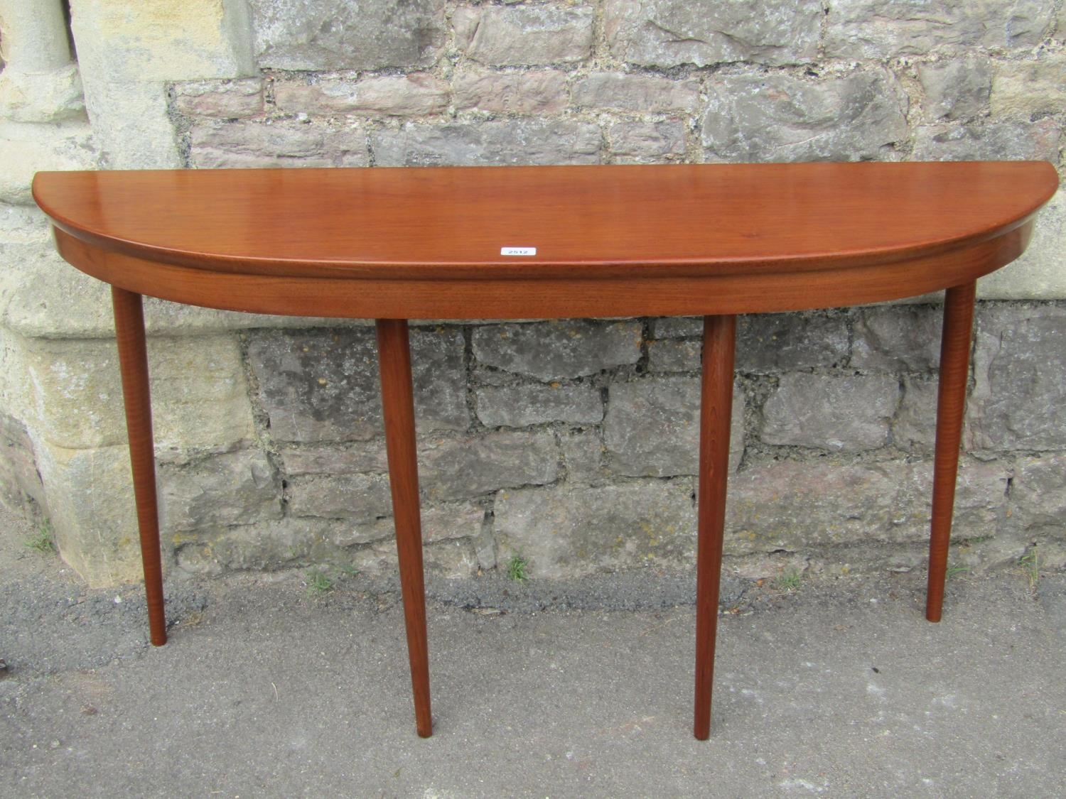 A mid 20th century hardwood demi lune hall/side table raised on four turned tapered supports 132cm x