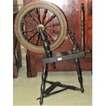 A traditional foot pedal operated spinning wheel, dark stained, principally in oak with turned