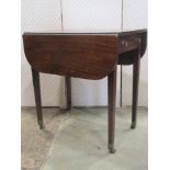 A Georgian mahogany Pembroke table with frieze drawer raised on square tapered legs with brass
