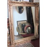 A large antique style wall mirror with rectangular plate, within a swept and moulded over painted
