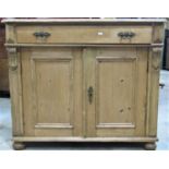 A 19th century European stripped pine side cupboard enclosed by a pair of rectangular moulded