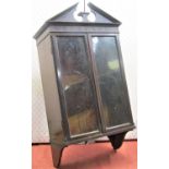 An Edwardian mahogany wall mounted display cabinet enclosed by two glazed panelled doors set beneath