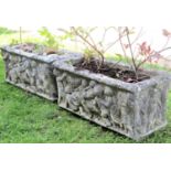 A pair of garden planters/flower troughs of rectangular form with raised cherub relief detail (