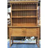 A 1920s stripped oak dresser, the base simply enclosed by a pair of rectangular panelled doors