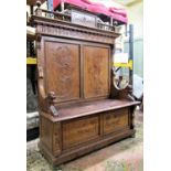 19th century continental walnut box settle with raised panelled back and overall carved detail
