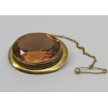 Antique style 9ct brooch set with a faceted oval orange stone, possibly paste, 10.5g