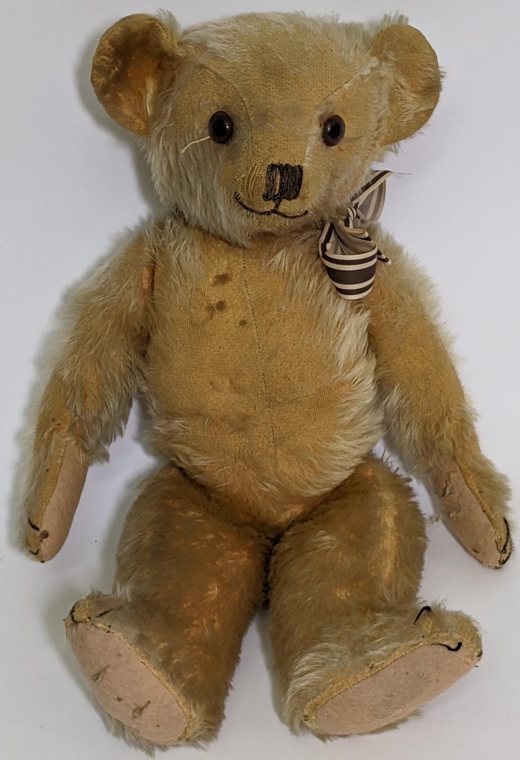 1930's teddy bear possibly by Merrythought with golden mohair, slight humped back, glass eyes,