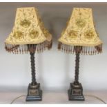 A pair of contemporary resin table lamps raised on square cut bases with hand worked shades