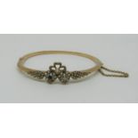 Antique yellow metal hinged bangle set with a sapphire, diamond and seed pearls, 10g (one pearl