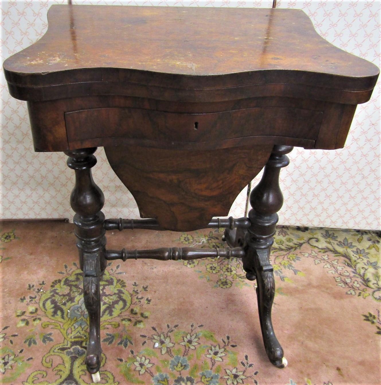 A mid Victorian period walnut and figured walnut ladies sewing/games table, the serpentine front