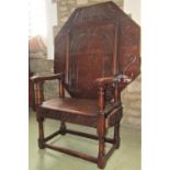 An old English style oak monks seat/table, the tilt octagonal top with carved arcaded and