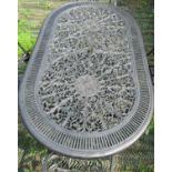 A cast aluminium garden terrace table of oval form with decorative pierced scrolling foliate top,