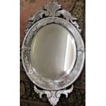 A Venetian wall mirror, the oval mirror plate within a further etched mirrored frame with shaped and