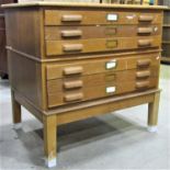 A vintage oak two sectional plan chest of six long drawers with moulded handles raised on square cut