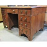 A 19th century stained pine kneehole twin pedestal writing desk, with inset tooled green leather