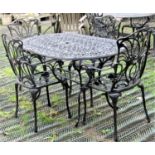 A contemporary cast aluminium garden terrace table of oval form with decorative pierced foliate