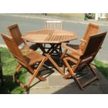 A contemporary partially weathered teak folding garden table with octagonal segmented slatted top