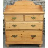 A Victorian stripped pine bedroom chest of two long and two short drawers with shaped back