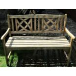 A contemporary hardwood two seat garden bench with slatted seat and curved lattice panelled back,
