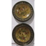 A pair of enamelled japanned plaques decorated with birds amidst foliage within further classical