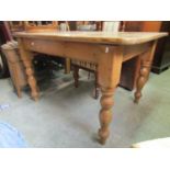 A stripped and waxed pine kitchen table, the rectangular top with rounded corners raised on four