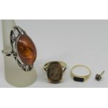 9ct tigers eye cameo ring, a 9ct onyx ring, an Eastern European silver amber ring and a single 9ct