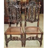 A pair of antique Carolean style side/dining chairs with carved scrolling acanthus and turned frames
