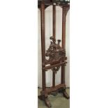 An unusual walnut floorstanding easel with carved and moulded framework and adjustable pierced and