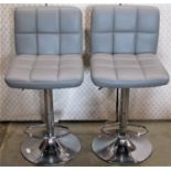 A pair of contemporary modernist swivel and height adjustable kitchen bar stools with stitched