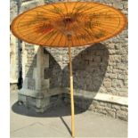A large Japanese parasol with bamboo shaft and hand painted decoration, 7ft tall approx