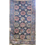 A good antique Kurdish rug decorated with bands of flowers upon a navy blue ground, 175 x 95 cm (AF)