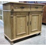A 19th century European stripped pine side cupboard enclosed by a pair of rectangular moulded