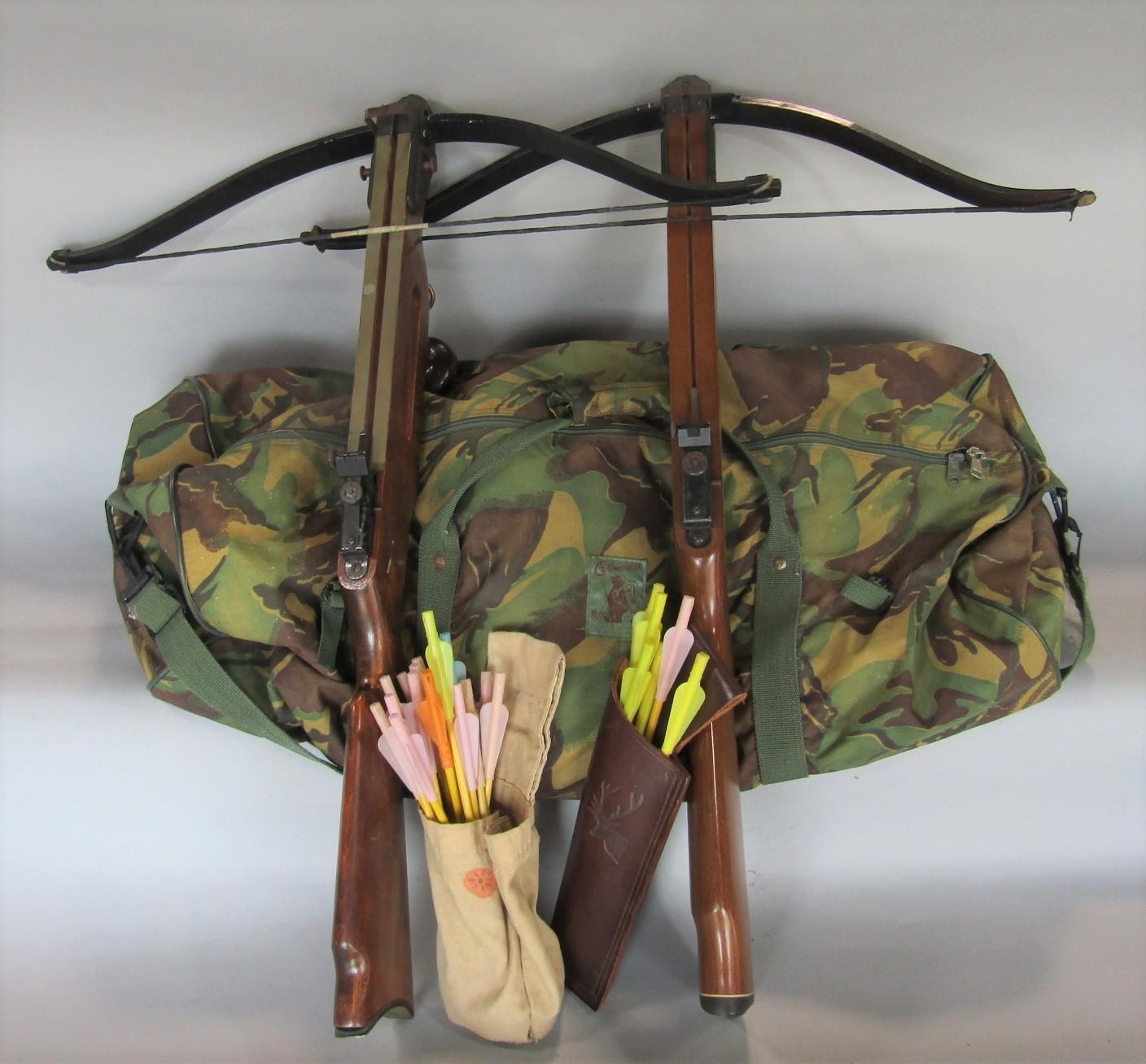 2 rifle cross bows together with a camouflage bag containing items of military uniform