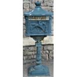 A reclaimed freestanding cast alloy post box, the simulated tiled roof with crown shaped finial over