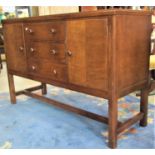 A Russell of Broadway oak sideboard enclosed by a pair of rectangular doors flanking tower of