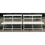 A pair of cream painted light steel framed two seat benches with timber lathes and rail back