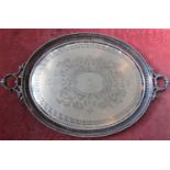 Large twin handled silver plated tray, the engraved bowl centrally decorated with a family crest