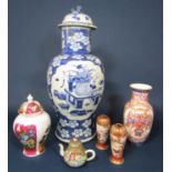 An oriental blue and white vase and cover with painted flower vase and trophy detail against a