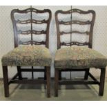 A pair of 19th century mahogany ladderback chairs with pierced splats and upholstered seats on