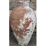 A terracotta jar of circular and tapered form with simple ribbed detail, traces of painted finish,