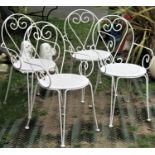 A set of four cream painted hoop back steel framed garden chairs, with pierced circular panelled