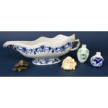 An 18th century oriental sauce boat with blue and white painted floral decoration to the interior