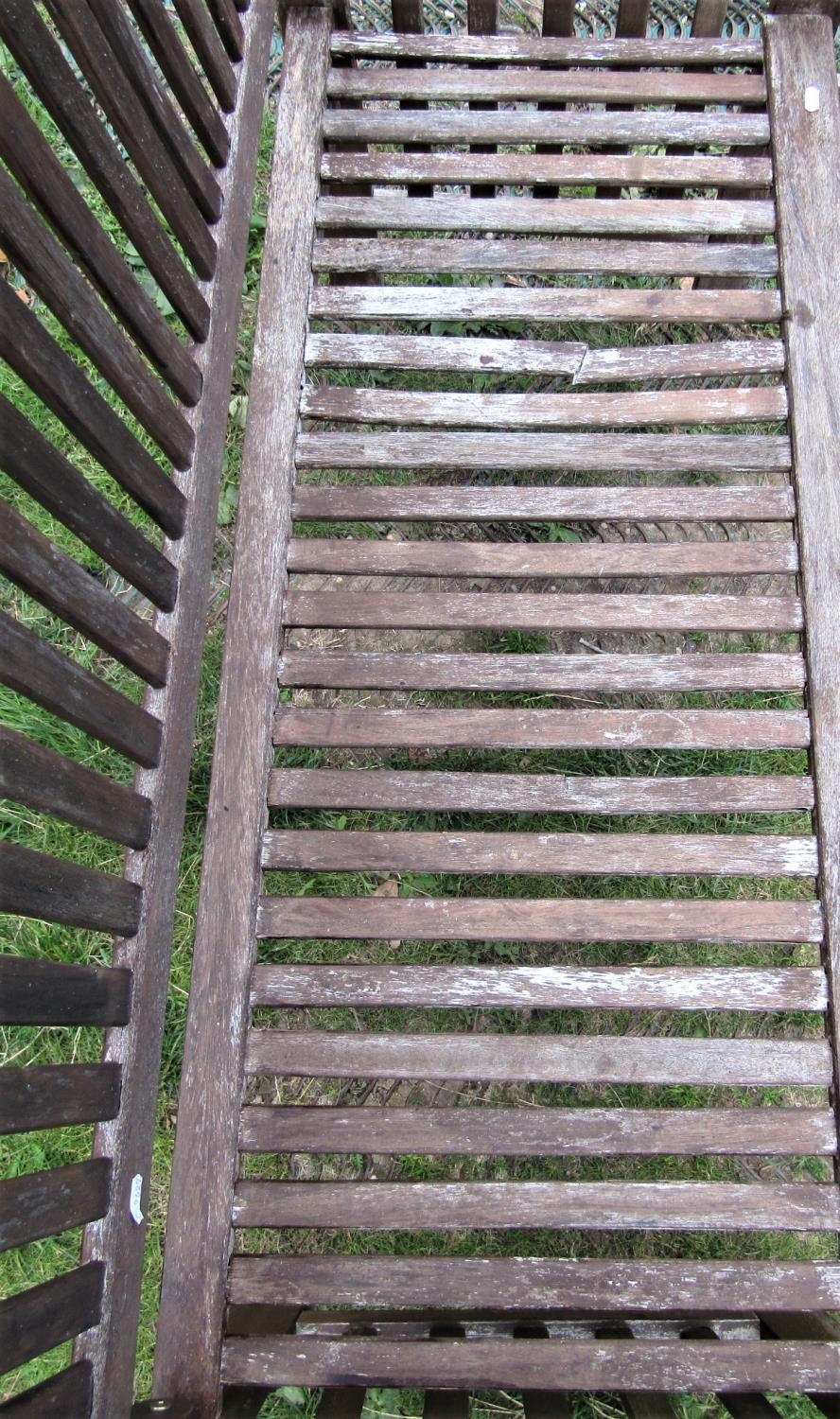 A contemporary weathered hardwood two seat garden bench with slatted seat, back and arms, (af) 126cm - Image 2 of 3