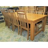 A contemporary light oak extending dining table of rectangular form with panelled top bifold